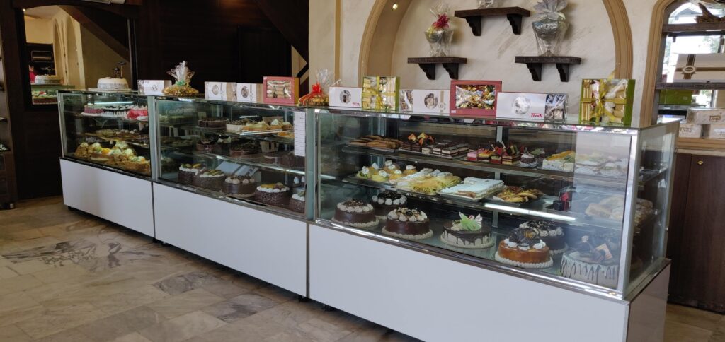 A display case with cakes on it showcasing Tivoli sweets.