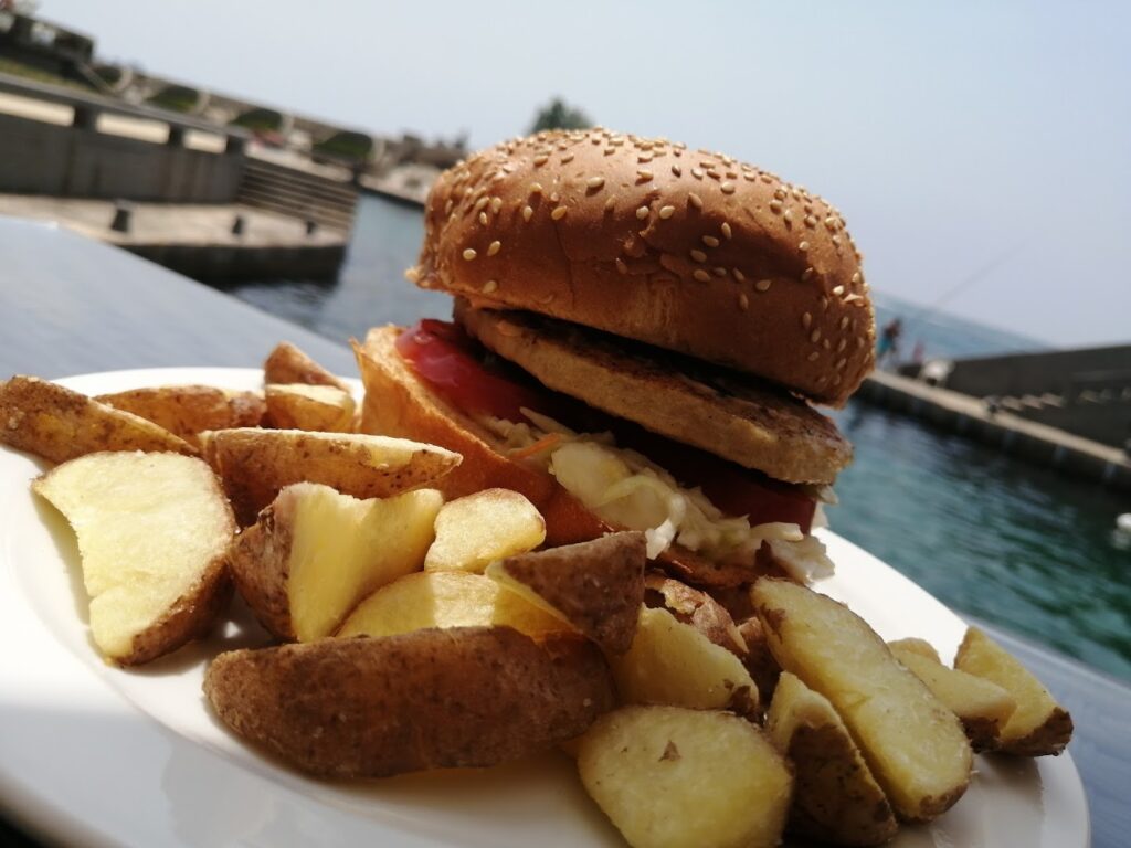 Triple K Catering serves a delicious combination of a burger and potatoes on a plate.
