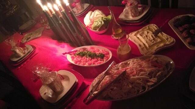 "A table with plates of food and candles, set up by Triple K Catering."