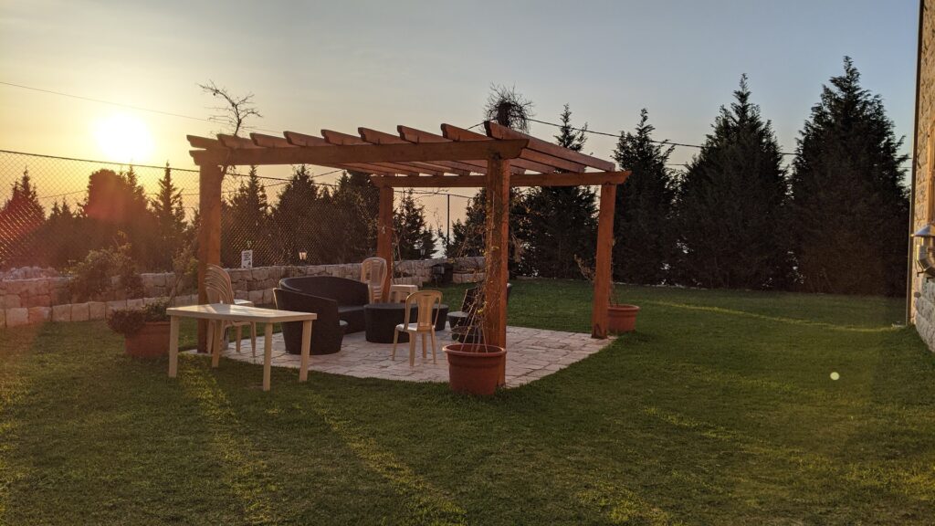 a patio with a pergola and chairs