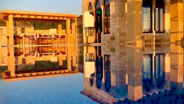 a pool with a building and a pergola