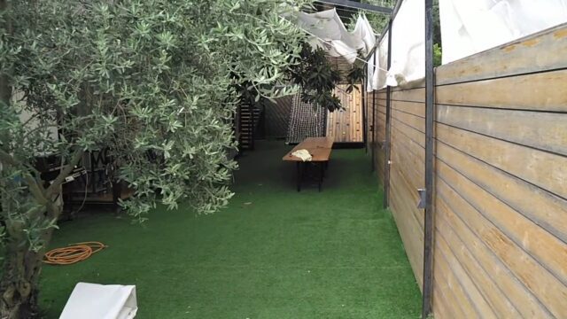 a wooden table and chairs on a green lawn