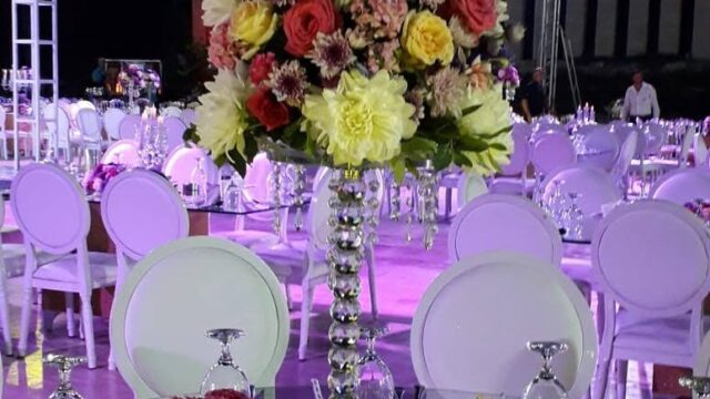 a table set up with chairs and flowers