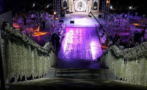 a stage with white flowers and a stage with people in the background