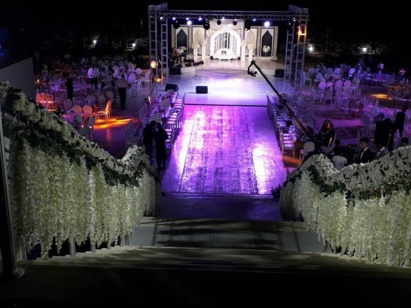 a stage with white flowers and a stage with people in the background