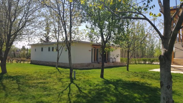 a white building with trees in the back