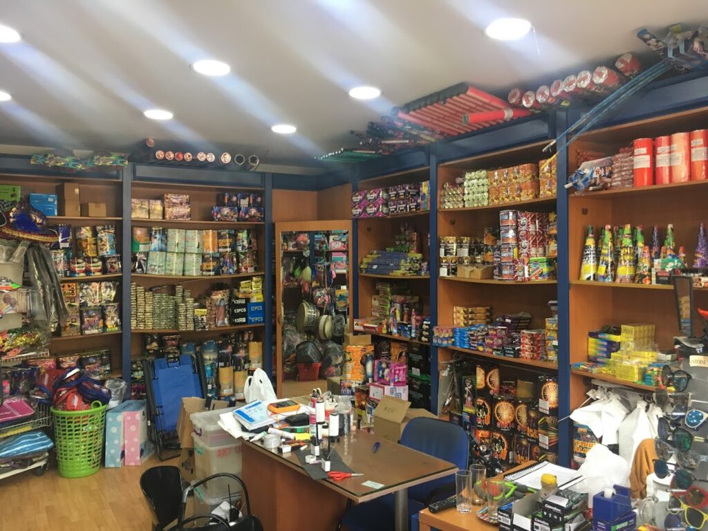 a store with shelves full of items, including the "Art of Fireworks".