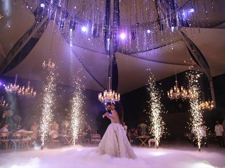 "A man and woman are gracefully dancing under a white tent at Platane Wedding Venues in North Lebanon."