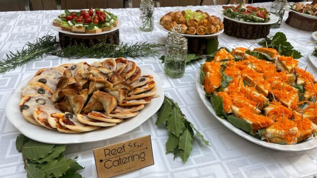 A table with food on it catered by Reef Catering.